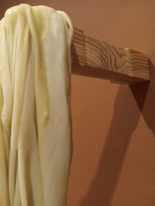 LATENCIA DEL PLIEGUE, 2025. Textil, cera y soportes de madera. Medias variables.