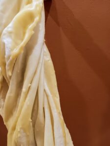 LATENCIA DEL PLIEGUE, 2025. Textil, cera y soportes de madera. Medias variables.